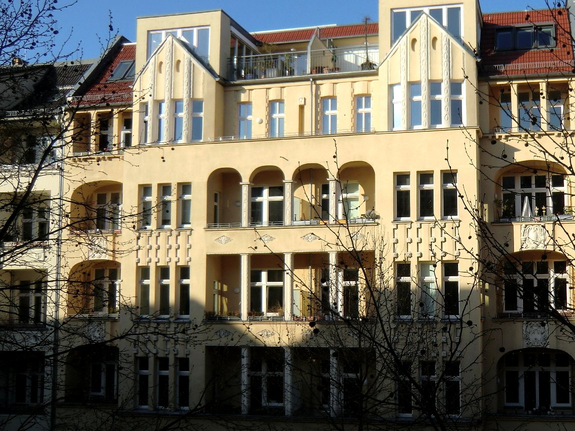 Gelbes Mehrfamilienhaus aus der Gründerzeit mit Säulen und Erkern in der Hufelandstraße im Prenzlauer Berg, Berlin