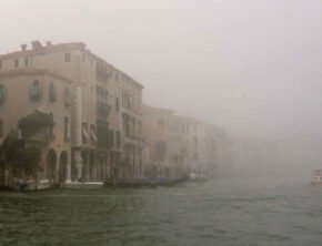 Historische Häuserzeile im Nebel am Wasser in Venedig