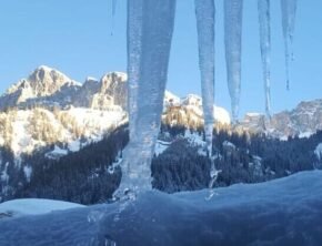 Eiszapfen vor alpinem Bergpanorama